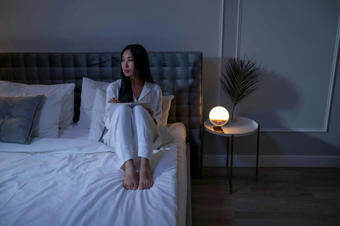 How to sleep better tonight — woman sleeping peacefully with silk sleep mask and bonnet on champagne mulberry silk pillowcase