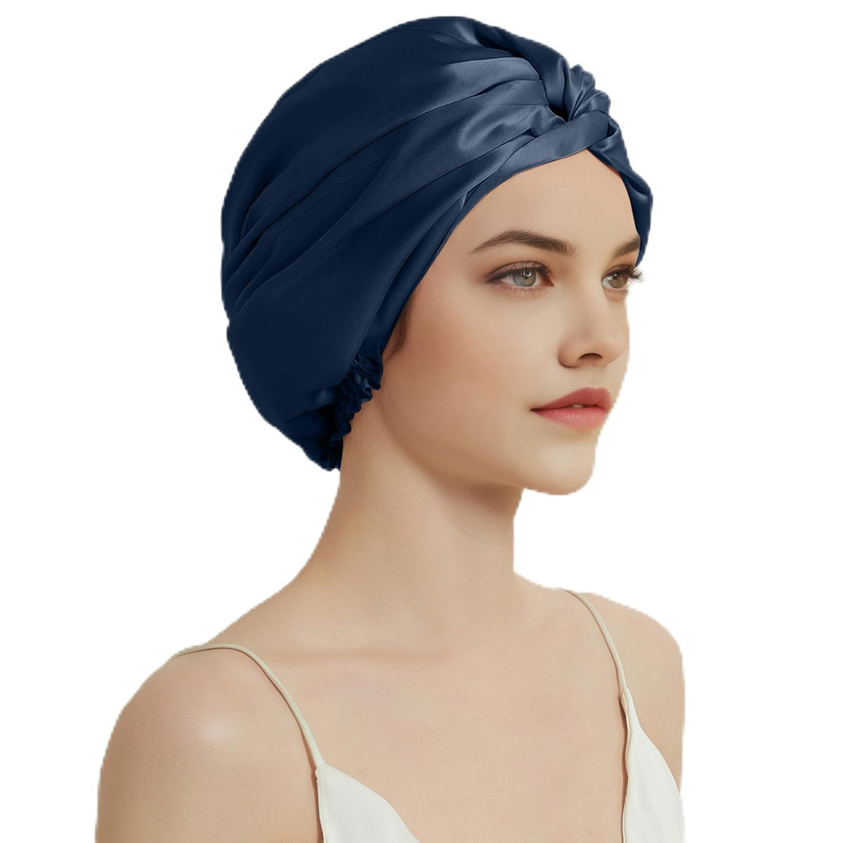 Model wearing a navy blue silk sleep bonnet with a twisted front and gathered edge.