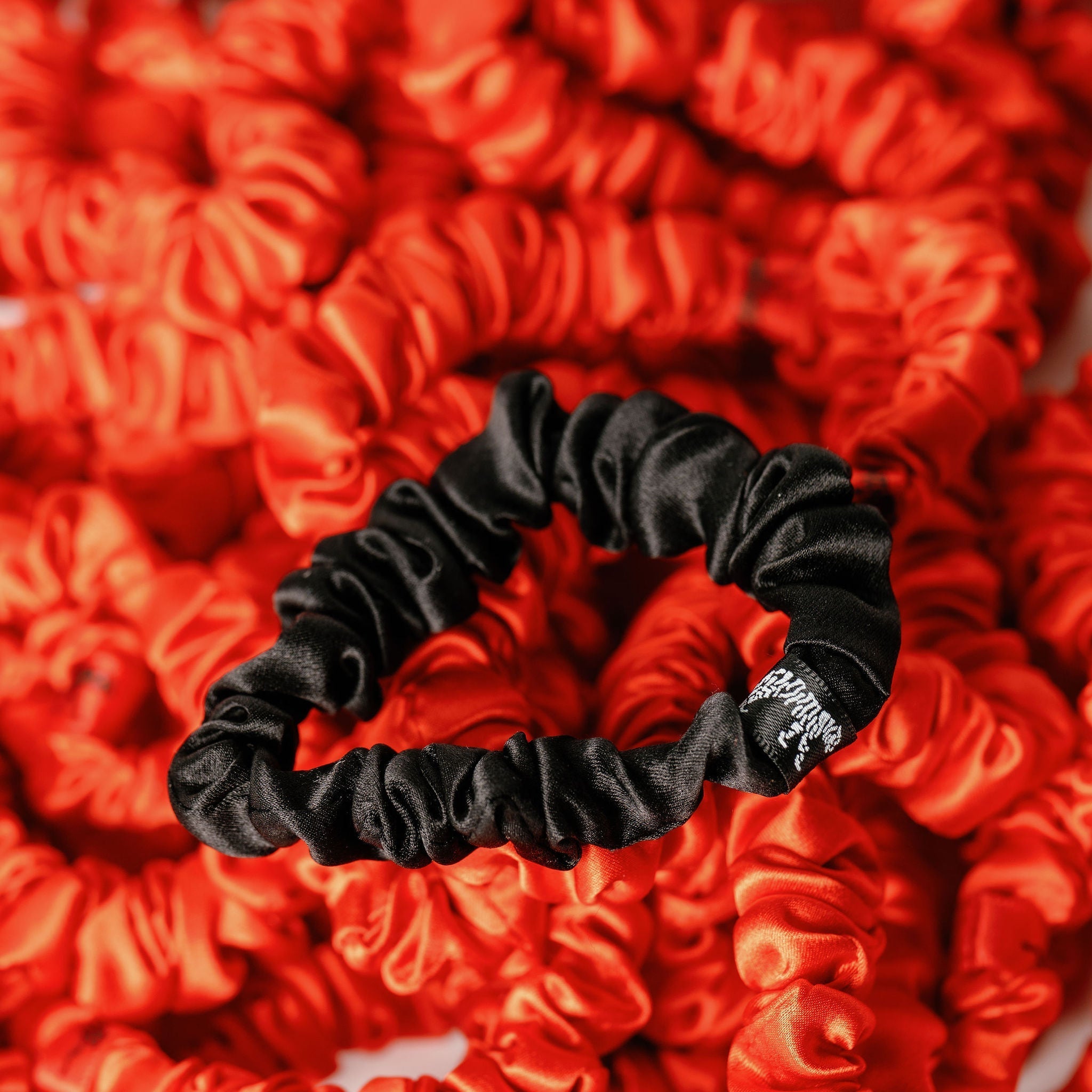LINA LENNOX organic silk small black scrunchie onyx black with smooth, shiny fabric, suitable for hair styling or accessories.