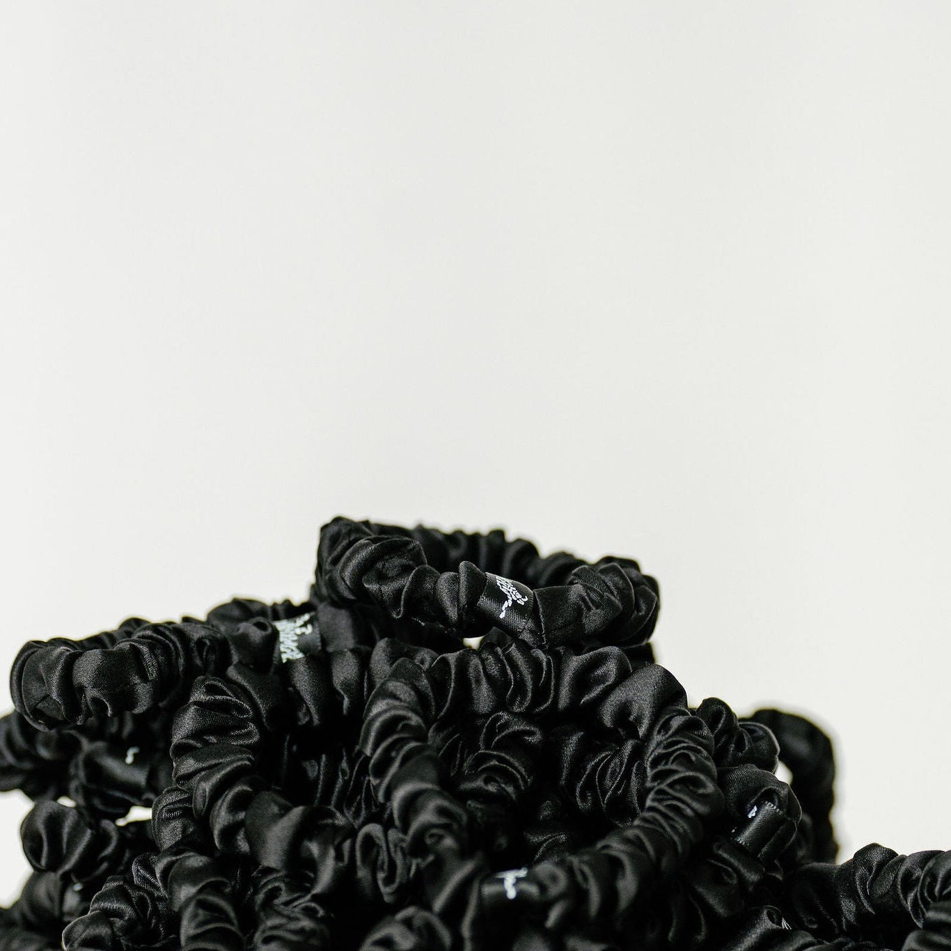 Organic silk black scrunchie by LINA LENNOX, small onyx black hair accessory with soft, glossy fabric and elastic band.