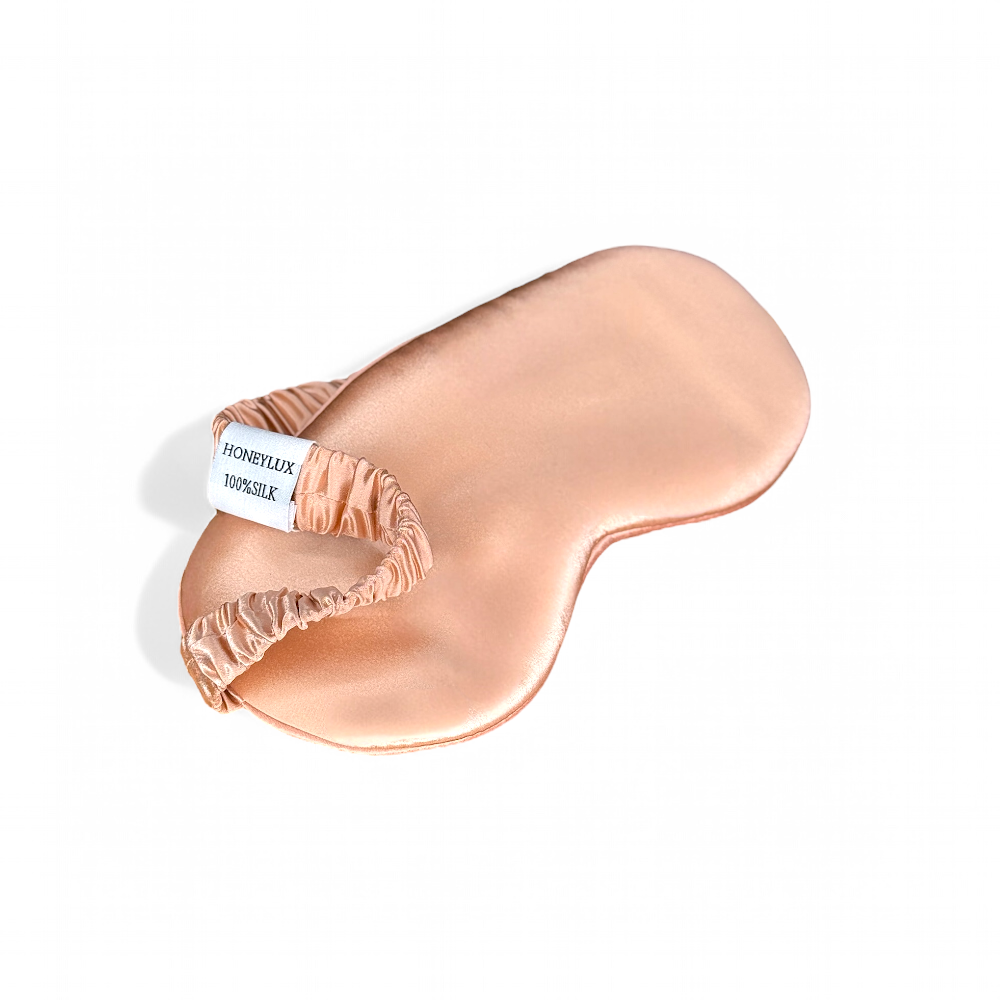 Organic silk sleep mask by Soreia in rose gold with blackout design, 22 Momme silk for comfortable night sleep.