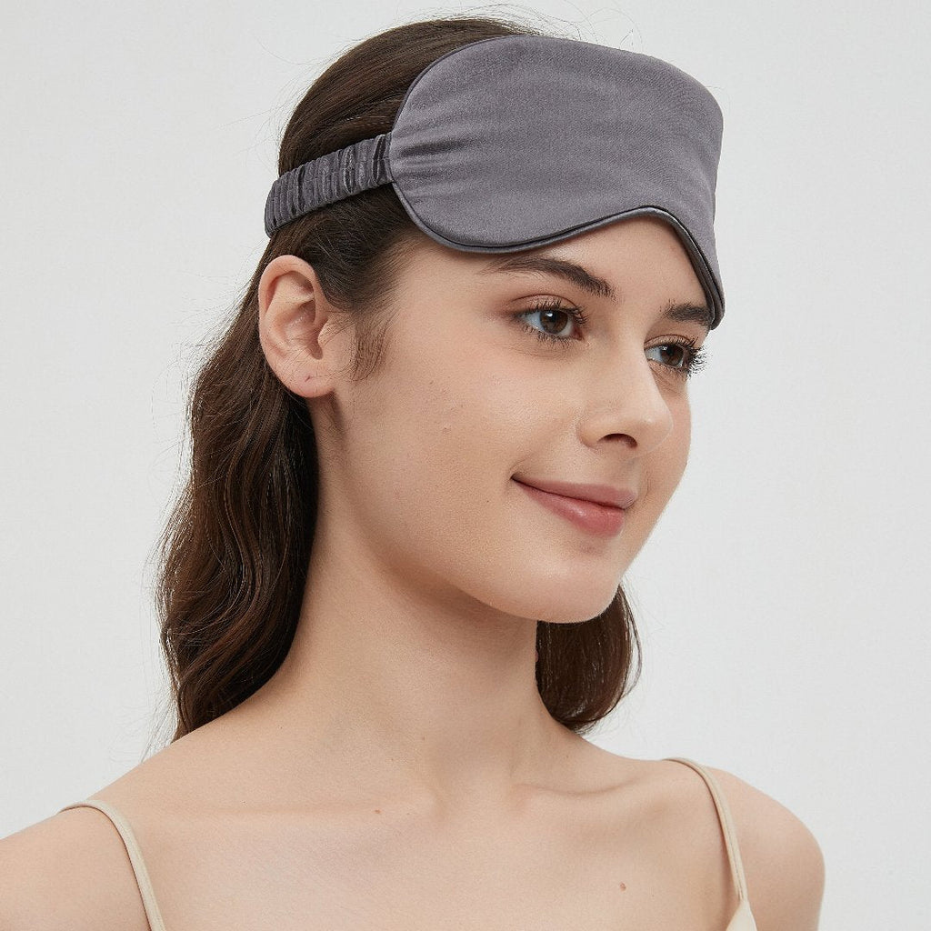 Grey Perle Silk Charmeuse Silk Sleep Mask resting gently over a pillow, showcasing soft, luxurious silk for restful sleep.