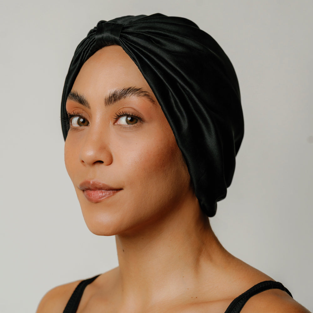 Black organic silk sleep bonnet by Soreia, made from 22 momme Mulberry silk, designed as a comfortable silk hair accessory.