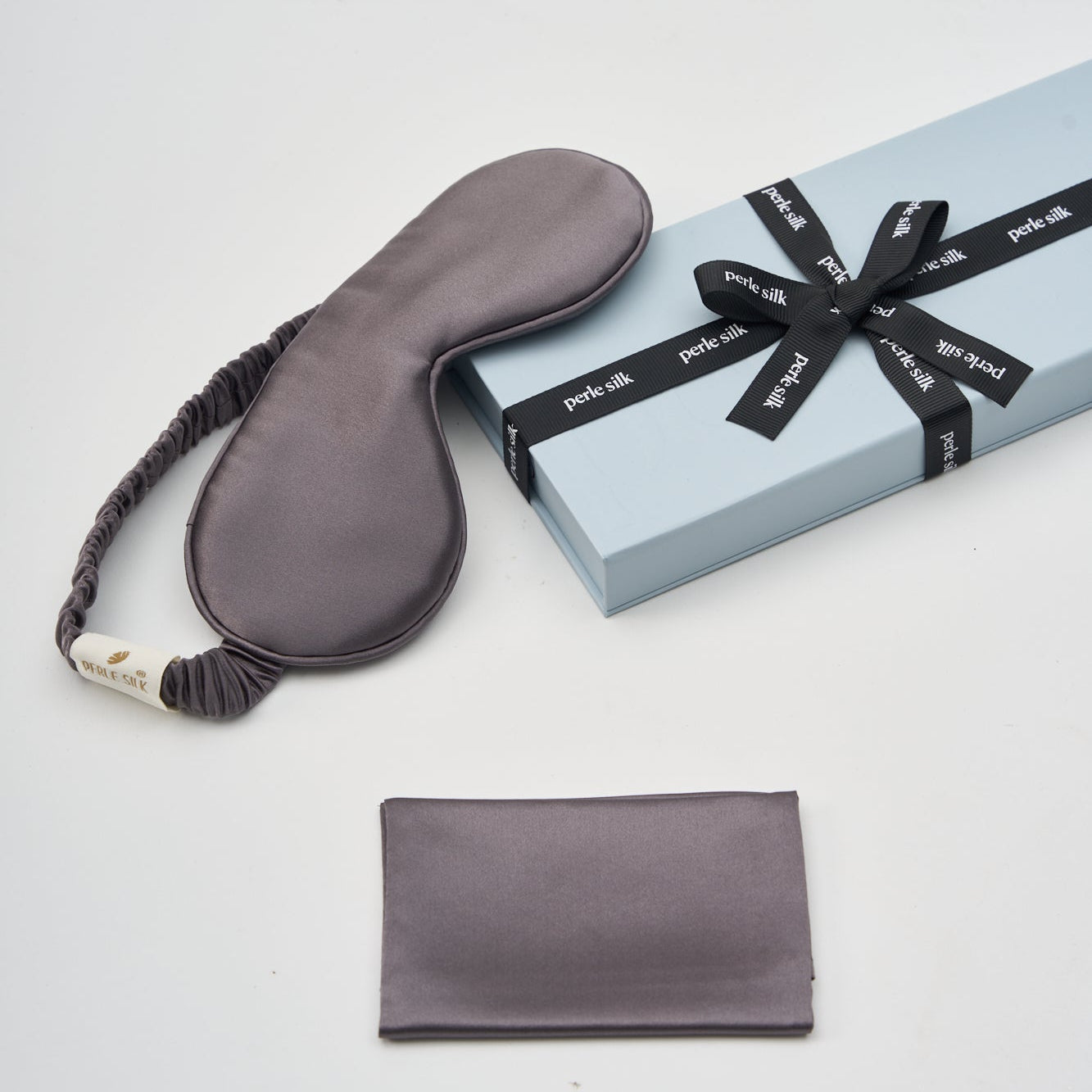 Charmeuse silk sleep mask by Perle Silk in charcoal color, displayed in a gift box, soft mulberry silk for restful sleep.