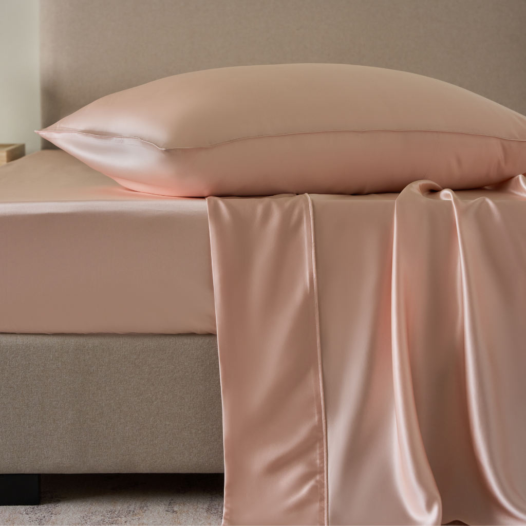 Soreia Charmeuse silk flat sheet in Rosewood, made from pure Mulberry silk, showcasing smooth, shiny fabric on a bed.