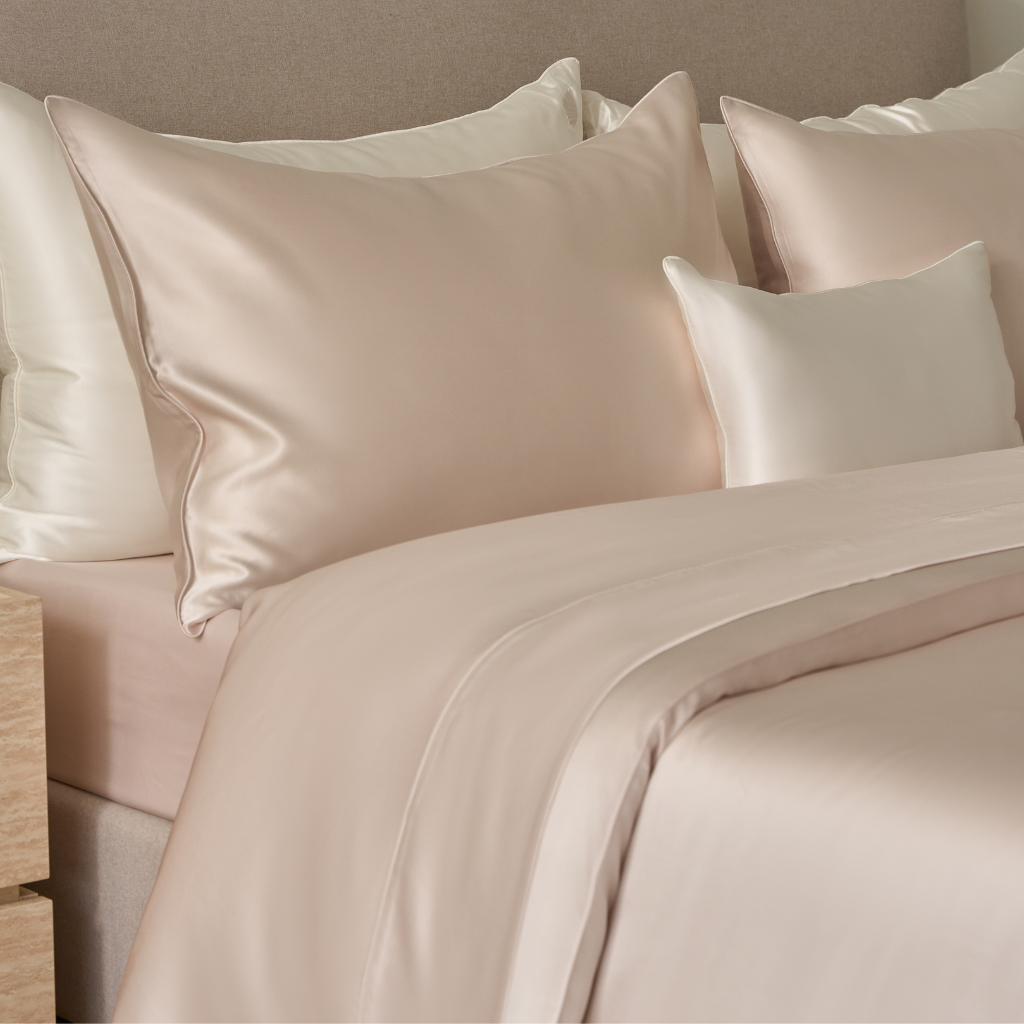 Blush pink Charmeuse silk flat sheet from Soreia, 22 Momme Mulberry silk, showcasing smooth, luxurious fabric detail.